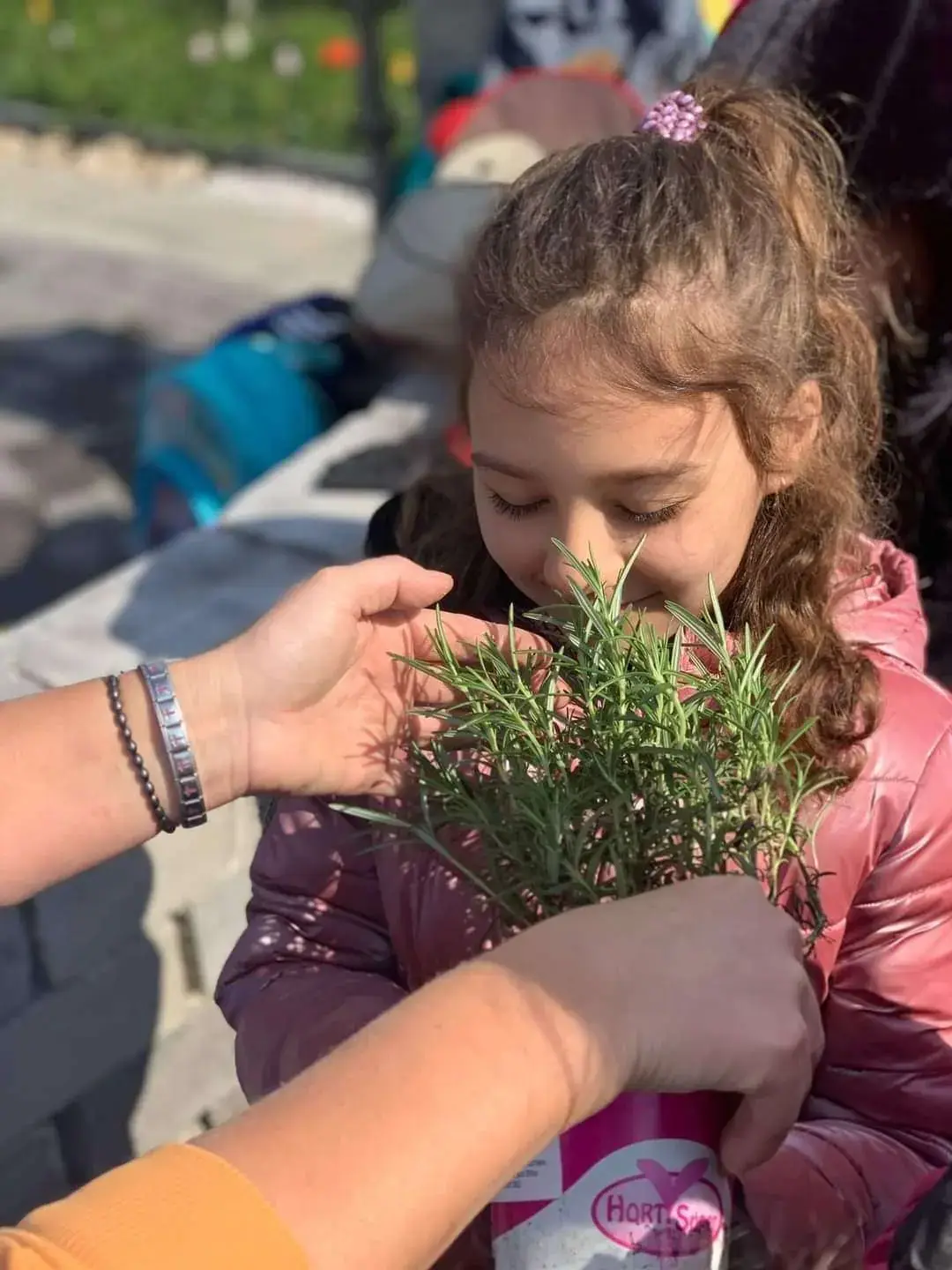 SEEDS Afterschool: fetiță mirosind o plantă aromatică